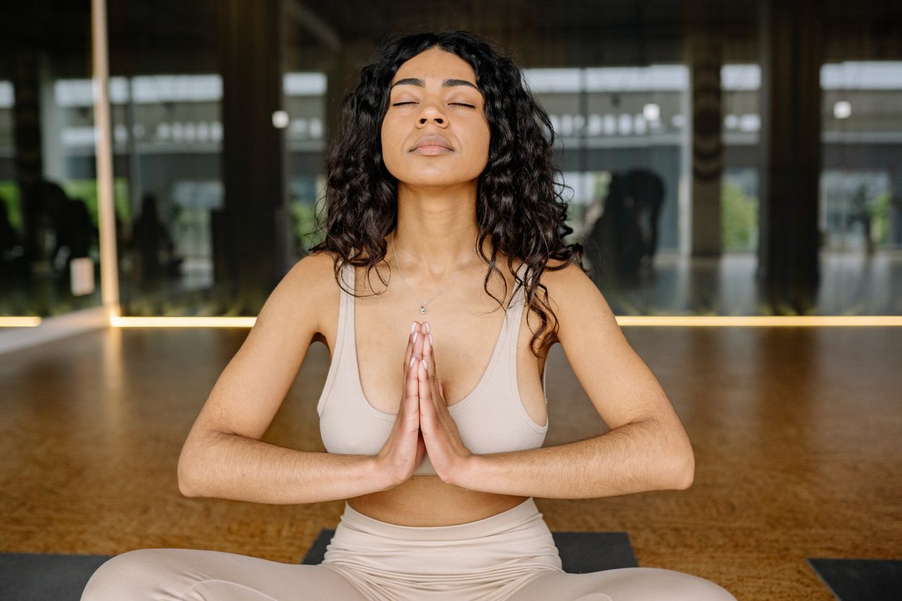 Contact Peaceful woman meditating in a yoga studio, embracing calmness and relaxation.
